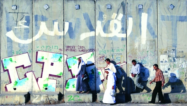 الصورة : ■فلسطينيون يحاولون عبور جدار الفصل العنصري لأداء الصلاة في الأقصى  |  أ.ف.ب