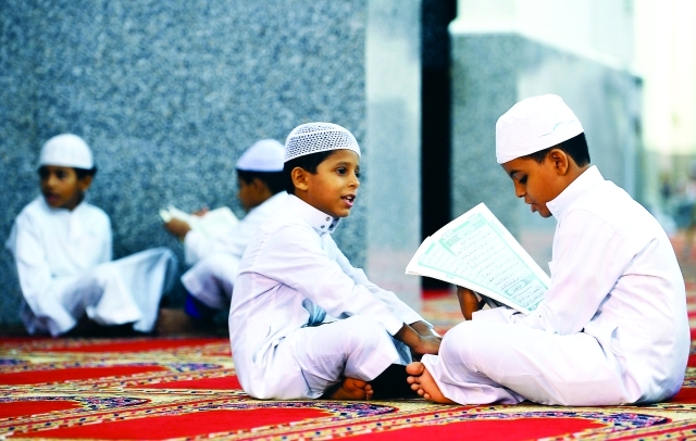 الصورة :  أطفال يقرأون القرآن الكريم
