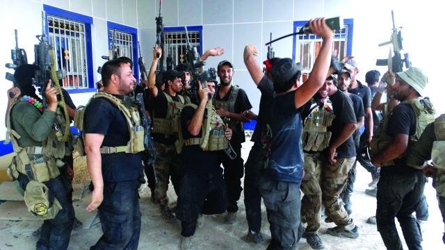 الصورة : ■ أفراد القوات الأمنية يلوحون مبتهجين بتحرير جامعة الأنبار  |  أ.ب