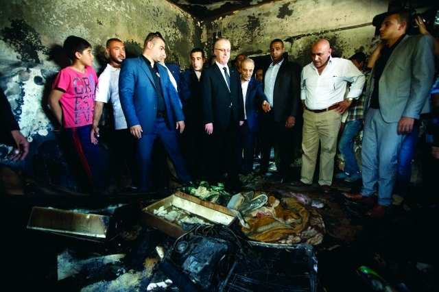 الصورة : رئيس الوزراء رامي الحمد الله يقف على آثار الجريمة  |  أ.ب