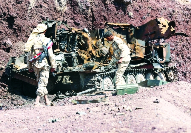 الصورة : ■ جنود يمنيون يتفقدون عربة مُدرعة للانقلابيين دُمرت في خط المواجهة بمأرب  |   رويترز