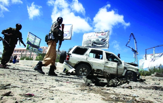 الصورة : ■ عناصر من الجيش الصومالي منتشرون في موقع تفجير انتحاري في مقديشو  |  أ.ف.ب