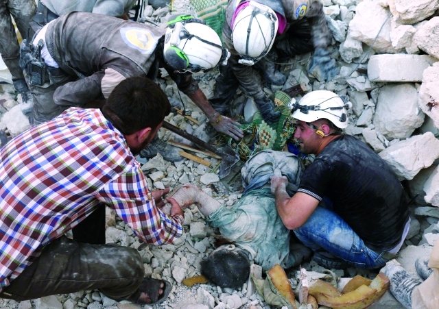 الصورة : عمال الدفاع المدني ينشلون جثثاً من تحت أنقاض أحد المباني في باب النيرب بحلب  ــ  أ.ف.ب