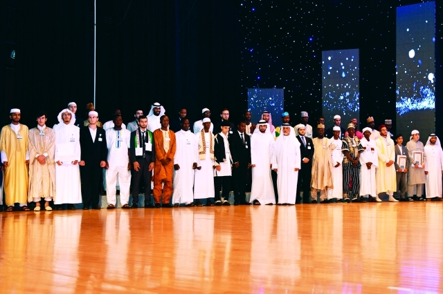 الصورة : ■ أحمد بن محمد يتوسط الفائزين والمشاركين في جائزة دبي للقرآن الكريم بحضور إبراهيم بوملحة  |  تصوير: محمد هشام