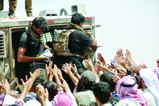 الصورة : ■ نازحون عراقيون يتدافعون للحصول على زجاجة مياه  |  رويترز