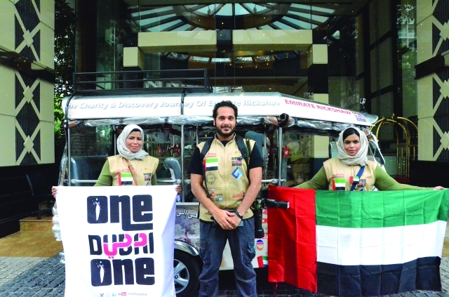الصورة : ■ هدى زويد وميثاء مبارك تحملان العلم وشعار فريق «ون دبي ون»