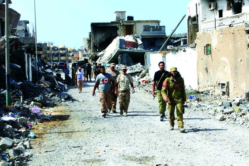 الصورة : جنود ليبيون يسيرون وسط مدينة سرت المدمرة | رزيترز