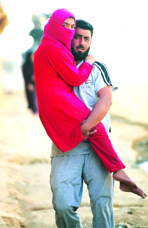 الصورة : رجل عراقي يحمل امرأة خلال فرارهم من الموصل |‏ أ.ف.ب