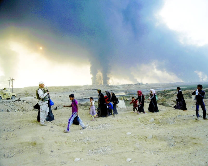 الصورة : الدخان يتصاعد والناس يفرون من منازلهم خلال الاشتباكات في الموصل/ أ.ف.ب