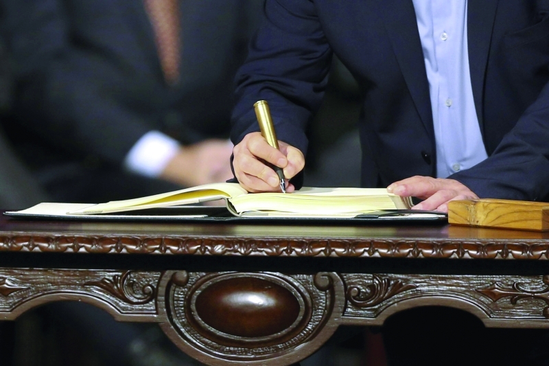 الصورة : ■ توقيع الاتفاق بقلم على شكل رصاصة  |  أ.ف.ب