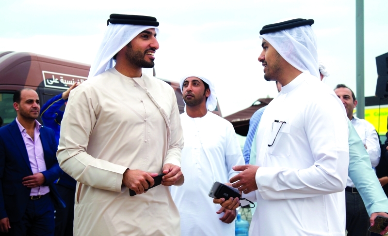 الصورة : ■ راشد بن حميد في حديث مع عبدالرحمن النعيمي خلال حضورهما اليوم الرياضي في عجمان  |  البيان