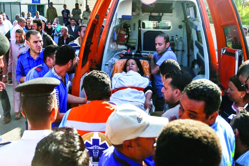 الصورة : ■ إحدى المصابات تنقل لتلقي العلاج بمستشفيات القاهرة  |  أ.ف.ب