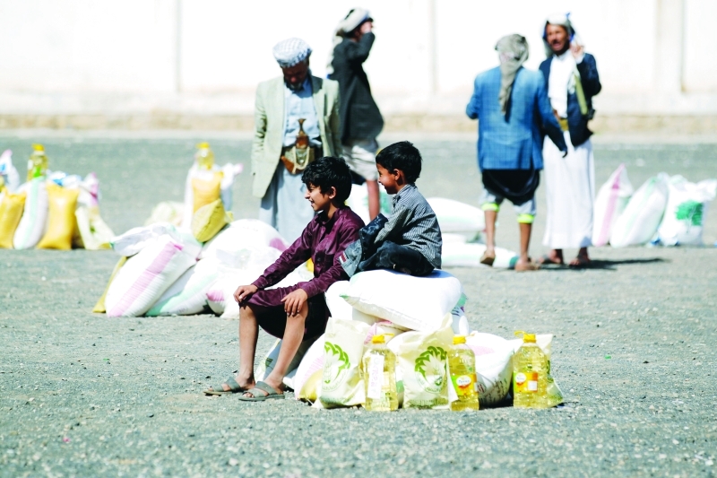 الصورة : ■  يمنيون يستلمون حصصهم من المساعدات الغذائية  |  أ.ف.ب
