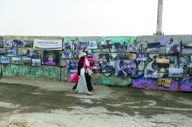 الصورة : Ⅶ صور تتهادى على جدار ميناء غزة  |  من المصدر