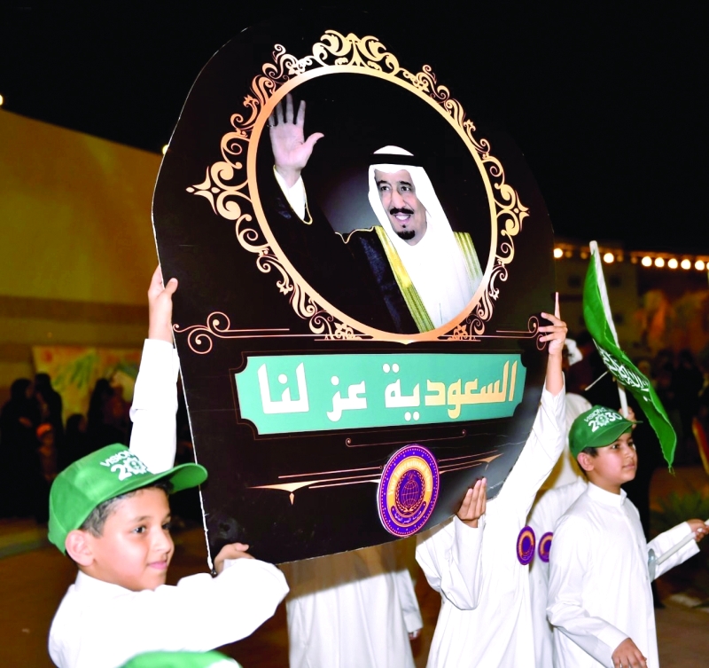 الصورة : أطفال سعوديون يرفعون صورة الملك سلمان في الاحتفالات بالعيد الوطني (واس)