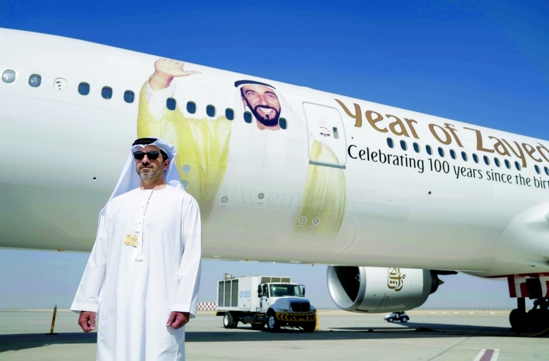 الصورة : ■  سموه يقف أمام طائرة لـ «الإمارات» تحمل ملصق «عام زايد»  | وام