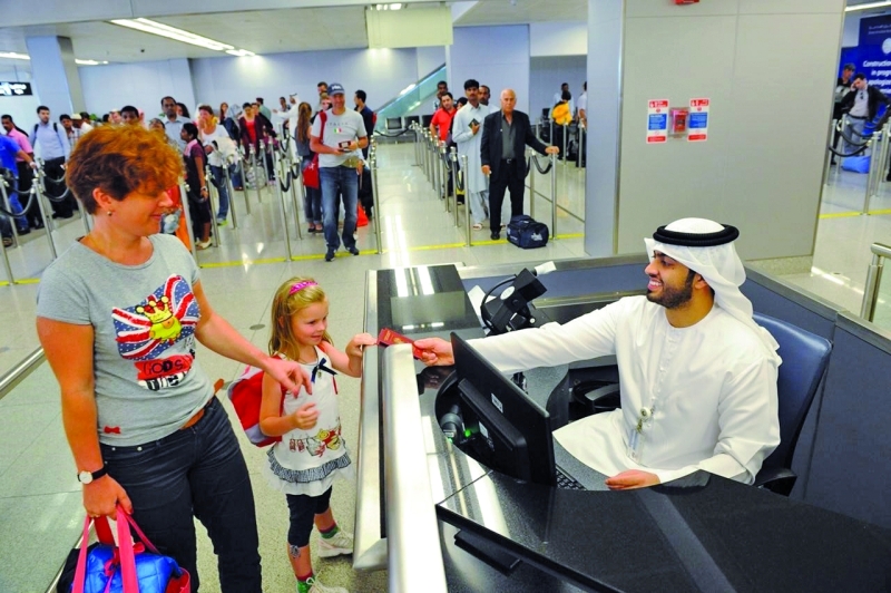 الصورة : موظف جوازات يستقبل الزوار بابتسامة بعد إنهاء إجراءات السفر  |  من المصدر
