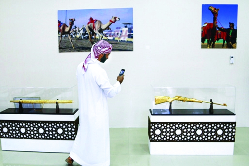 الصورة : ■ زائر في المعرض  يلتقط صوراً لجوائز هجن الرئاسة