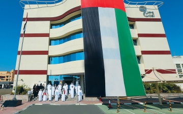 الصورة: الصورة: وصل ترفع العلم على سارية المبنى الرئيسي
