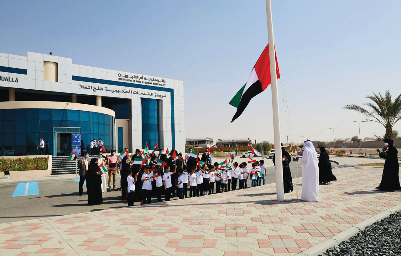 علي بن سعود يرفع العلم أمام مقر بلدية أم القيوين