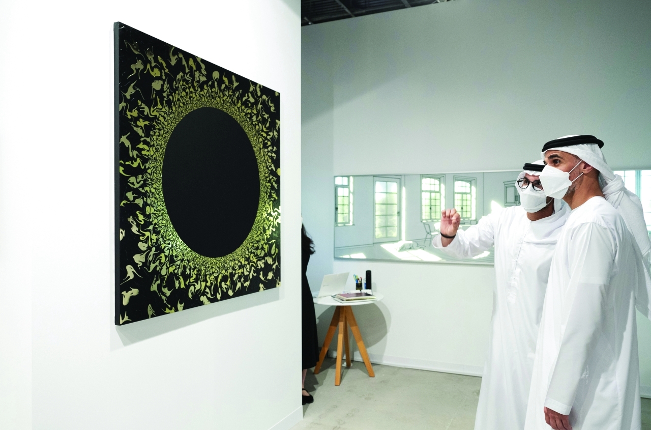 الصورة : خالد بن محمد بن زايد خلال اطلاعه على أحد الأعمال في المعرض  |  وام