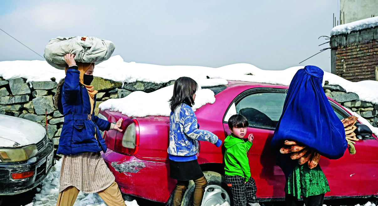 الصورة : أسرة أفغانية تعود إلى بيتها بعد أن جمعت الحطب لمواجهة البرد القارس في كابول | أ.ف.ب