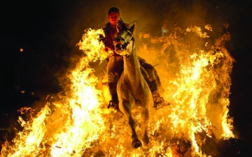 الصورة: الصورة: فرسان إسبانيا يقفزون فوق النيران لدحر الأوبئة