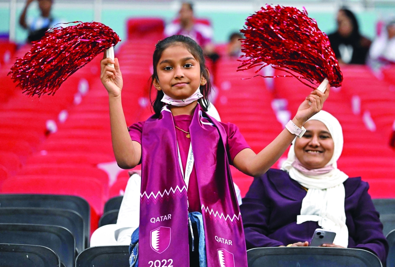 الصورة : A young Qatar fan attends the Qatar 2022 World Cup Group A football match between the Netherlands and Qatar at the Al-Bayt Stadium in Al Khor, north of Doha on November 29, 2022. (Photo by Alberto PIZZOLI / AFP)