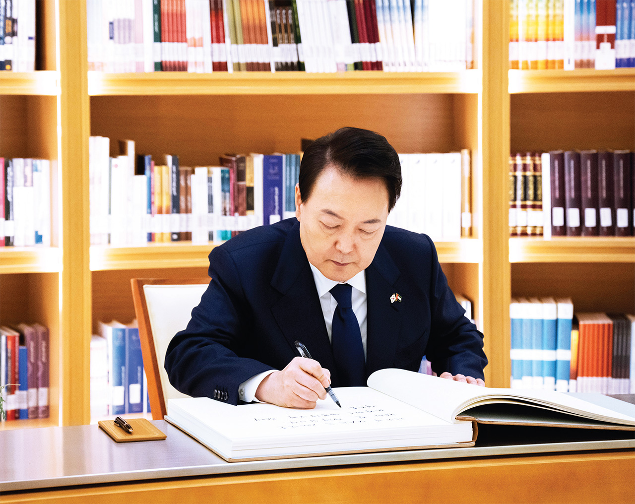 الصورة : الرئيس الكوري يدوّن كلمة في سجل كبار الزوار