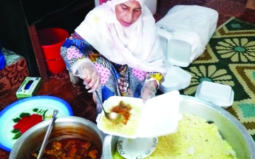 الصورة: الصورة: شريفة الحوسني.. «أم العمال» توزع وجبات الإفطار مجاناً