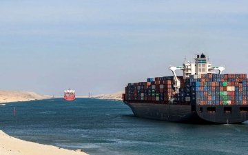 الصورة: الصورة: جنوح سفينة بقناة السويس وزوارق القطر تحاول تعويمها