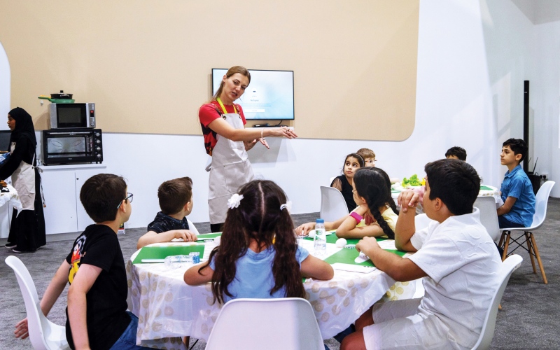 الصورة: الصورة: الأطفال يحضّرون وجبات صحية مقتبسة من قصة «ذات الرداء الأحمر»