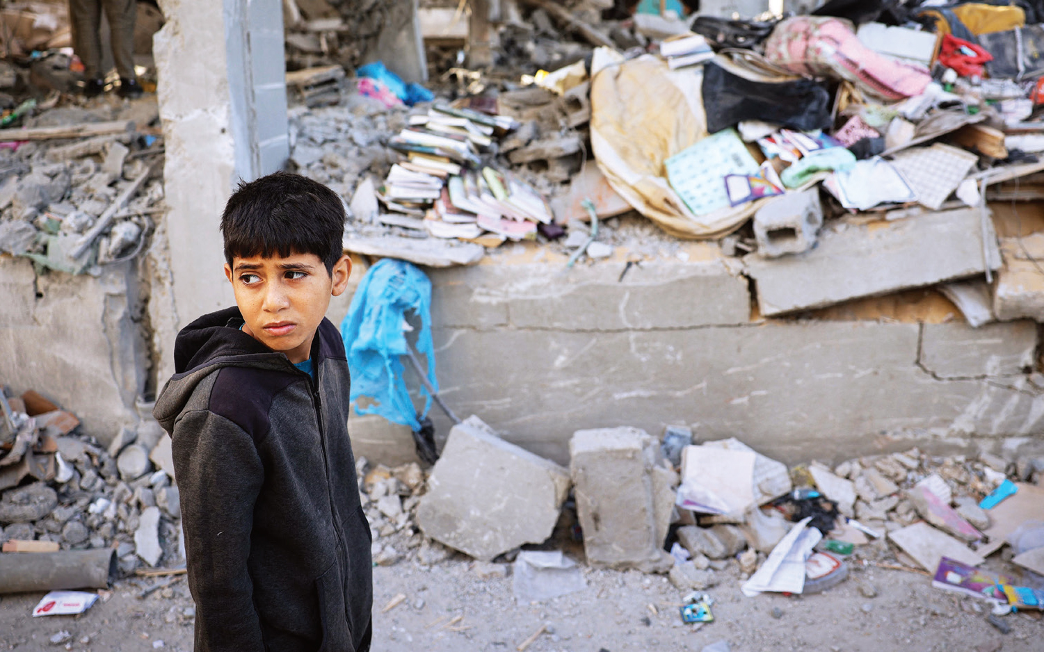 الصورة : طفل فلسطيني يقف أمام مبنى دمره القصف الإسرائيلي في رفح | أ.ف.ب